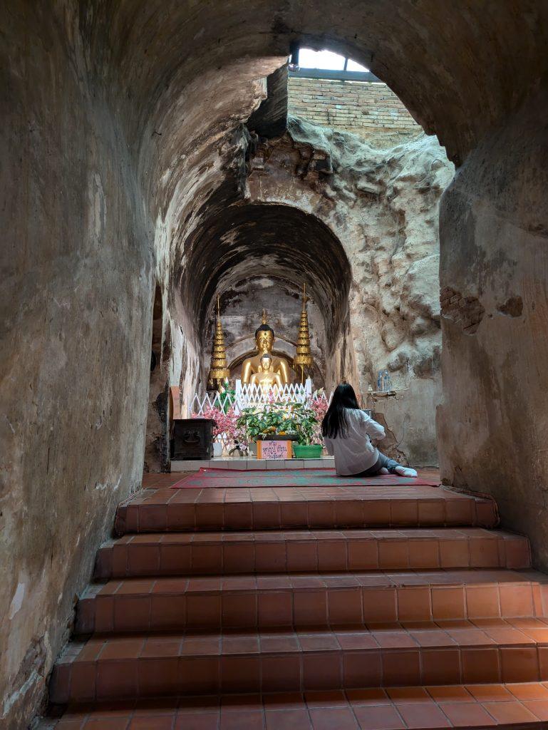 Mujer reza ante una imagen de Buda en los túneles de Wat Umong