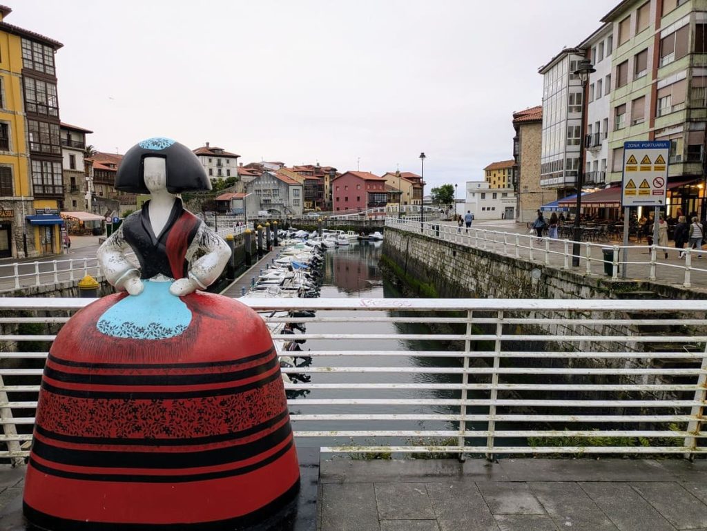 Puente de Llanes con la escultura de la menina vestida de llanisca