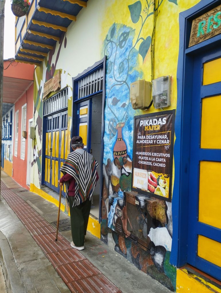 Un anciano pasea por la calle de Filandia con el poncho típico
